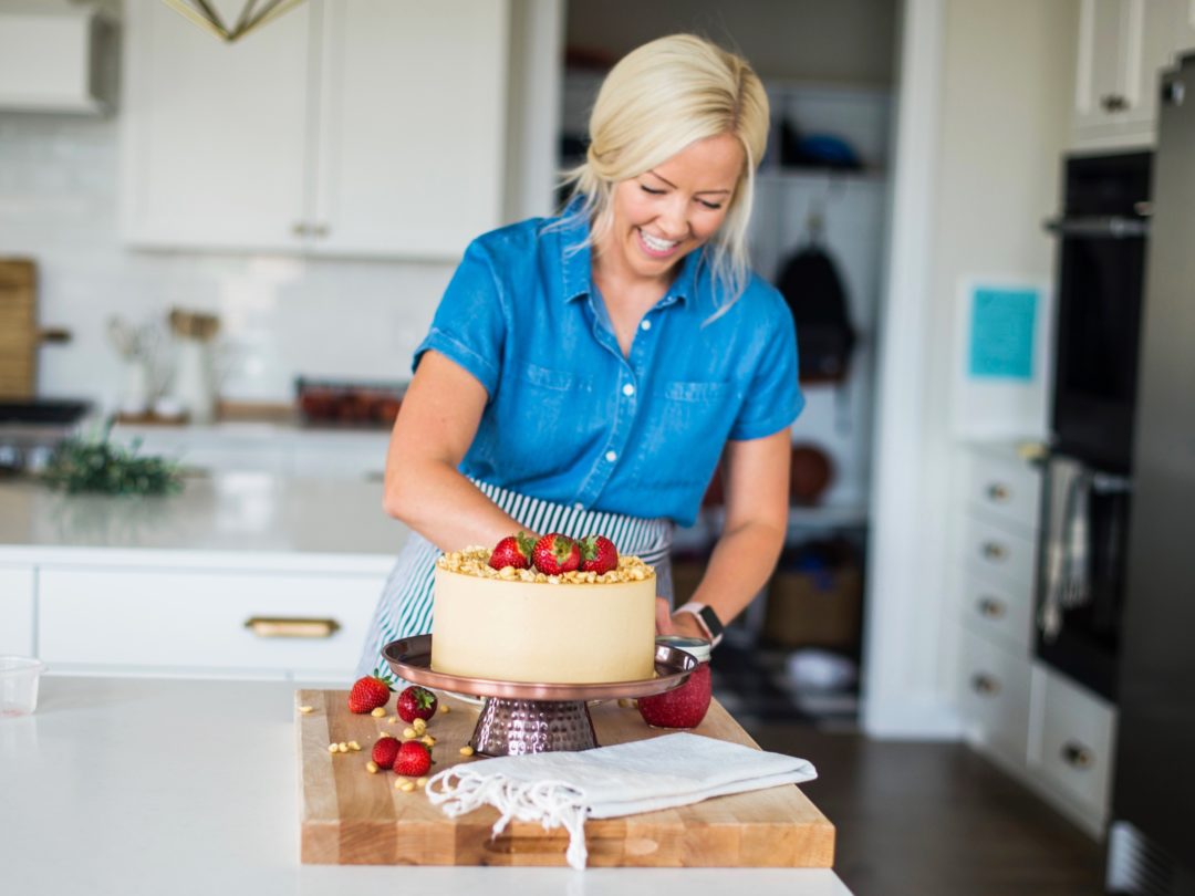 Woman in kitchen with cake.
