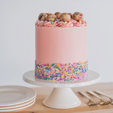 Sprinkle Cookie Dough Cake - tender white cake layers with chocolate chip and sprinkles cookie dough and vanilla buttercream. #cakebycourtney #birthdaycake #cookiedoughcake #sprinkles #cake #easycakerecipe