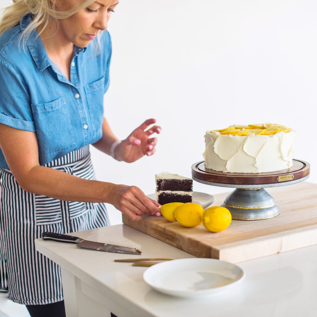 Woman setting up a cake photoshoot.