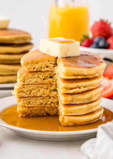 A stack of pancakes with a section cut out.