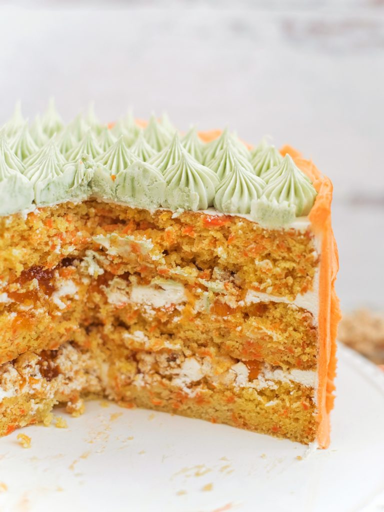 Carrot Apricot Cake - carrot ginger cake layers with white chocolate buttercream, apricot filling and a pretzel crunch #cakebycourtney #carrotcake #whitechocolatebuttercream #cake #eastercake #carrotcakeforeaster #easterdessert