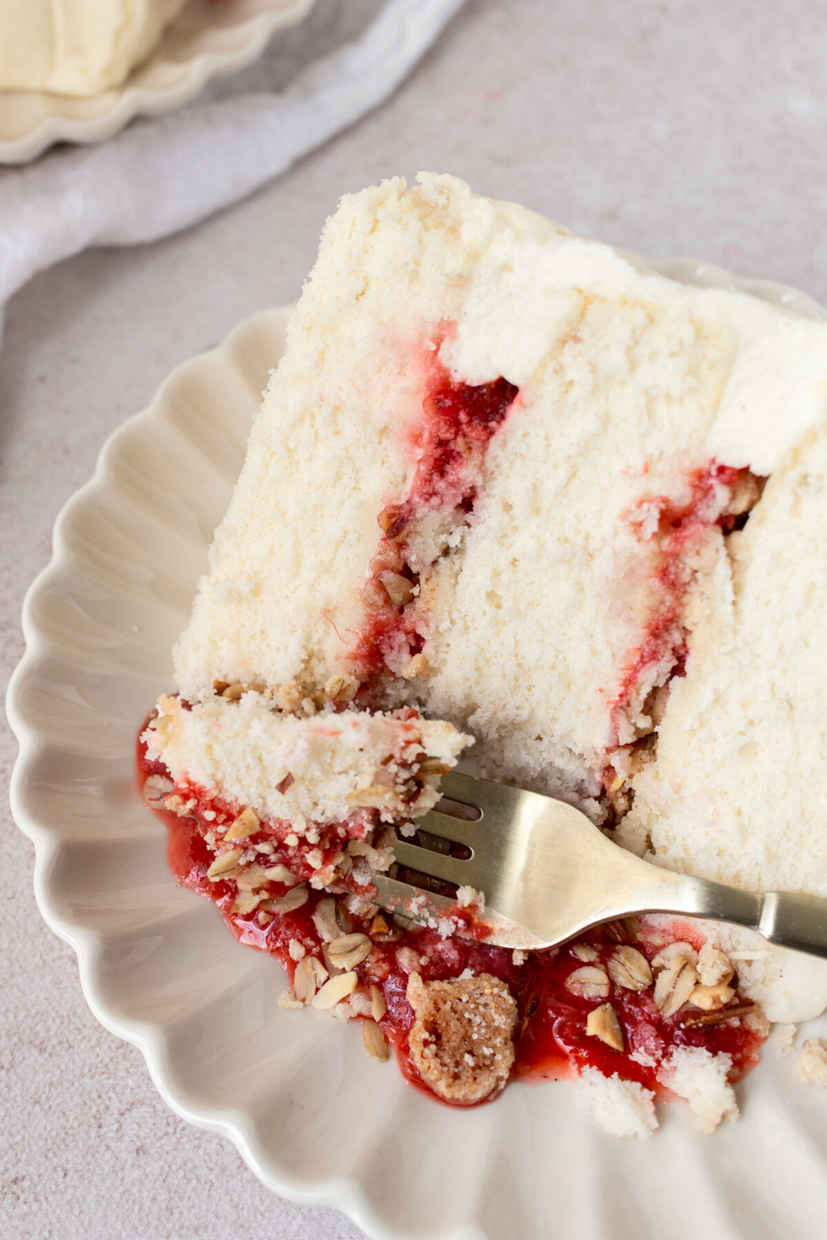 A slice of layered cake with a bite taken out of it on a fork.