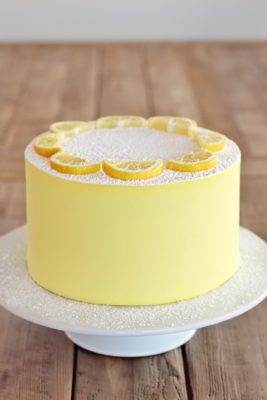 Round yellow lemon cake on top of spinning cake table.