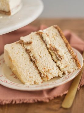 Creme Brûlée Cake: vanilla bean cake layers baked on a graham cracker crust, filled with vanilla bean custard and covered in a vanilla bean buttercream #cakebycourtney #cake #cremebrulee #cremebruleecake #cakerecipe #vanillabeancake #vanillacake