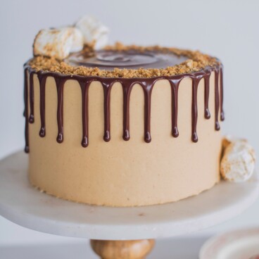 The ultimate s'mores cake for peanut butter lovers! Graham cracker cake layers with a toasted marshmallow filling, toasted graham crackers, chocolate ganache and peanut butter buttercream.