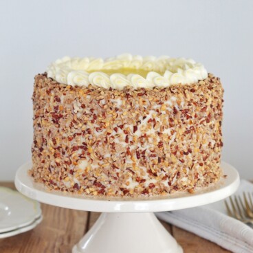 Hummingbird Cake: layers of banana and pineapple spice cake, pineapple curd, cream cheese buttercream and toasted candied pecans. #cakebycourtney #hummingbirdcake #cake #hummingbirdcakerecipe #creamcheesefrosting #creamcheesebuttercream #pineapplecurd #pineapple