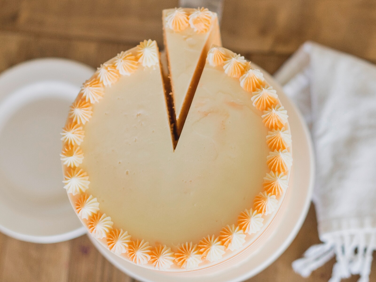 Orange and white Creamsicle Cake with a slice taken out.