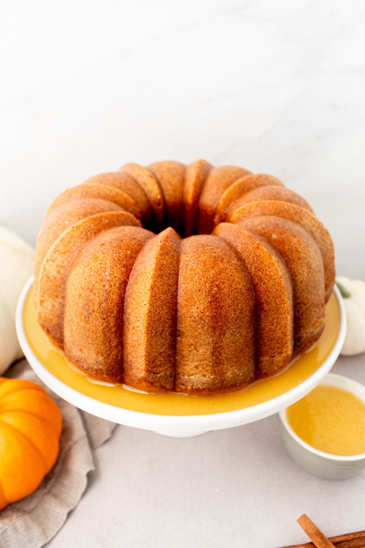 A pumpkin bundt cake on a cake stand.