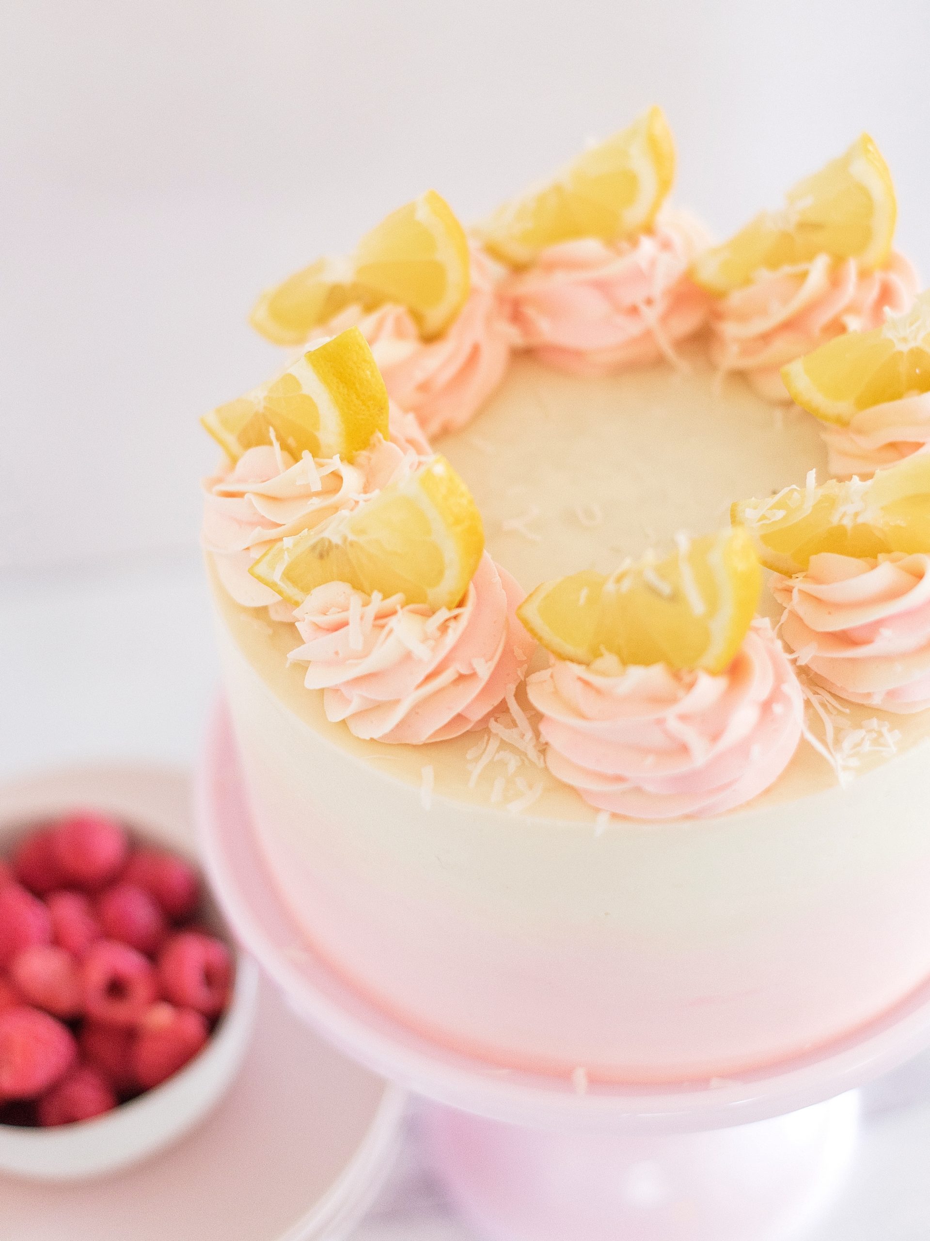 Coconut Lemon Raspberry Cake - coconut cake layers, lemon curd, raspberry cream filling, and coconut buttercream. #cakebycourtney #coconutcake #bestcoconutcake #lemoncurd #raspberrycream #raspberryfilling #coconutbuttercream #summercake #bestsummerdessertrecipes #summercakes #summerdessertrecipes 