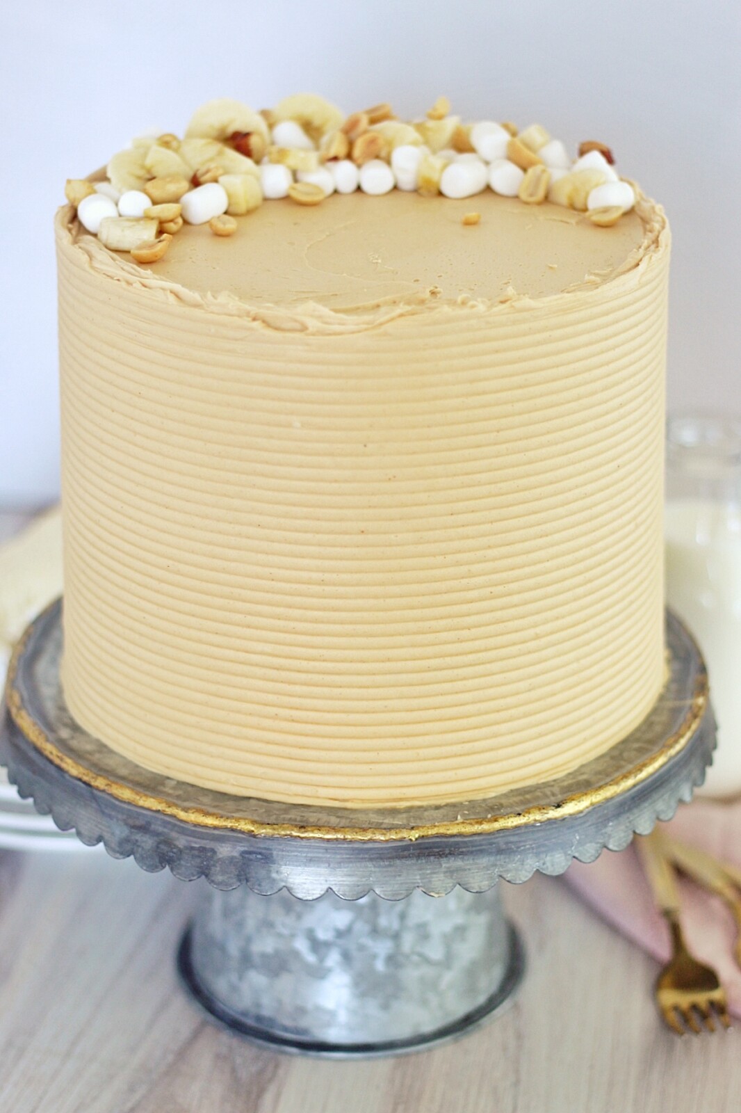 Fluffernutter Cake - tender white cake layers with banana cream filling, toasted marshmallow filling and peanut butter buttercream #fluffernutter #fluffernuttercake #cakerecipe #peanutbutterdessert #peanutbutterbuttercream #thebestpeanutbutterbuttercream #bananacream #bananapudding #cakebycourtney #layeredcake
