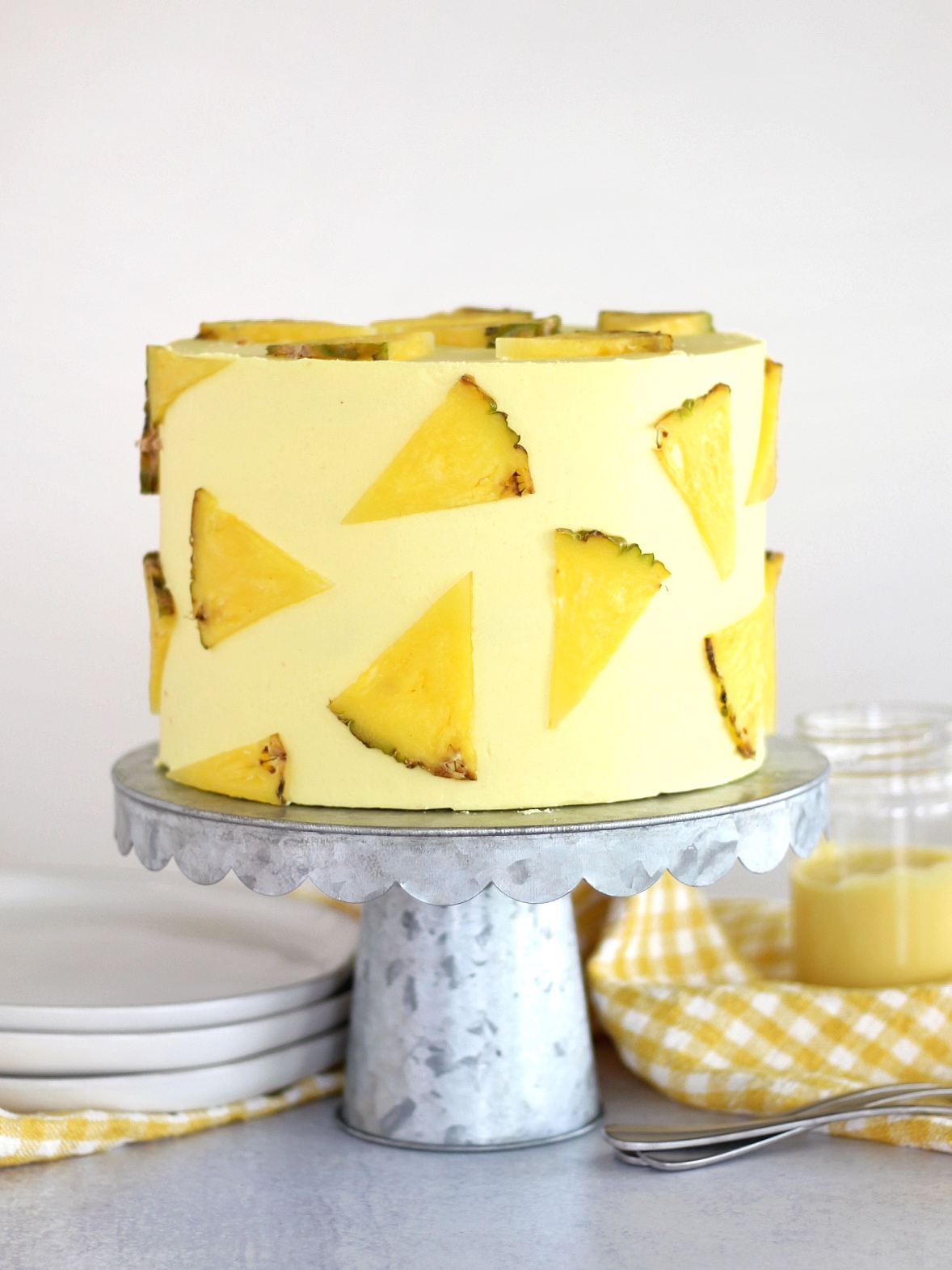 Pineapple Dole Whip Cake - the most delicious pineapple cake inspired by Disney's Dole Whip ice cream. This Pineapple Dole Whip Cake is filled with layers of pineapple cake, pineapple curd and pineapple buttercream #cakebycourtney #cake #pineapplecake #pineapplebuttercream #howtomakecake #summercake #pineapple #summerdessert #pineapplecakerecipe #cakerecipe #homemadeicing #homemadecake #howto makebuttercreamfrosting #frostingrecipe #buttercreamrecipe