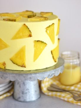 Pineapple Dole Whip Cake - the most delicious pineapple cake inspired by Disney's Dole Whip ice cream. This Pineapple Dole Whip Cake is filled with layers of pineapple cake, pineapple curd and pineapple buttercream #cakebycourtney #cake #pineapplecake #pineapplebuttercream #howtomakecake #summercake #pineapple #summerdessert #pineapplecakerecipe #cakerecipe #homemadeicing #homemadecake #howto makebuttercreamfrosting #frostingrecipe #buttercreamrecipe