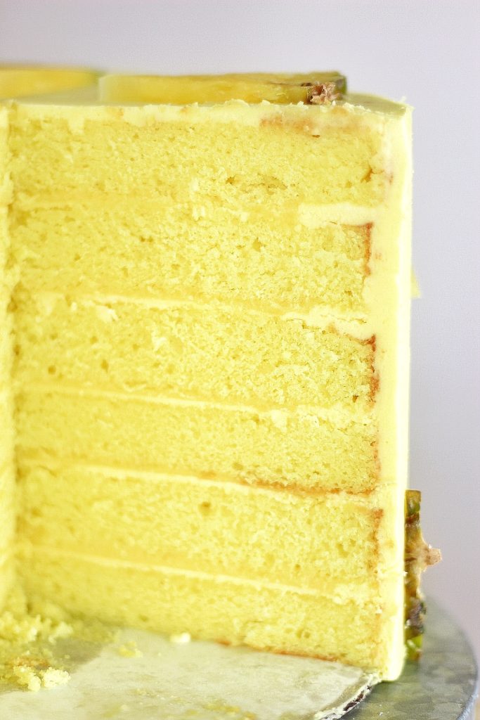 Pineapple Dole Whip Cake - the most delicious pineapple cake inspired by Disney's Dole Whip ice cream. This Pineapple Dole Whip Cake is filled with layers of pineapple cake, pineapple curd and pineapple buttercream #cakebycourtney #cake #pineapplecake #pineapplebuttercream #howtomakecake #summercake #pineapple #summerdessert #pineapplecakerecipe #cakerecipe #homemadeicing #homemadecake #howto makebuttercreamfrosting #frostingrecipe #buttercreamrecipe