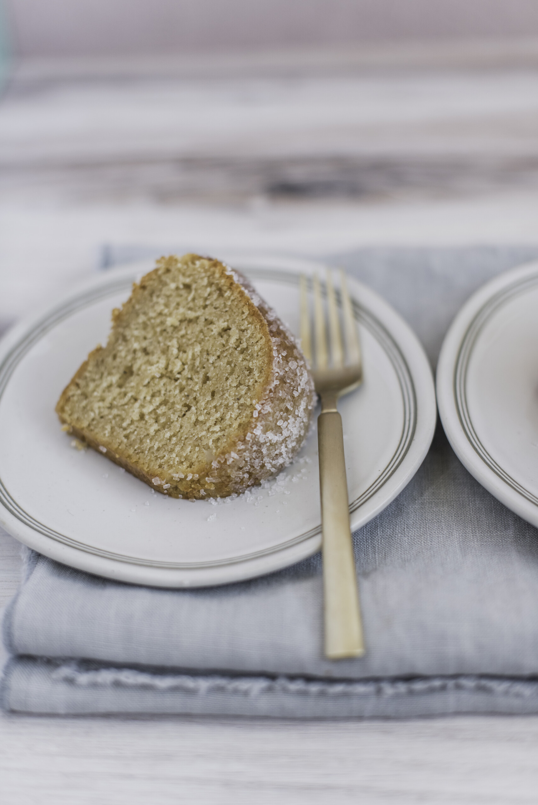 A slice of apple cider donut bundt cake on a plate with a light blue napkin.