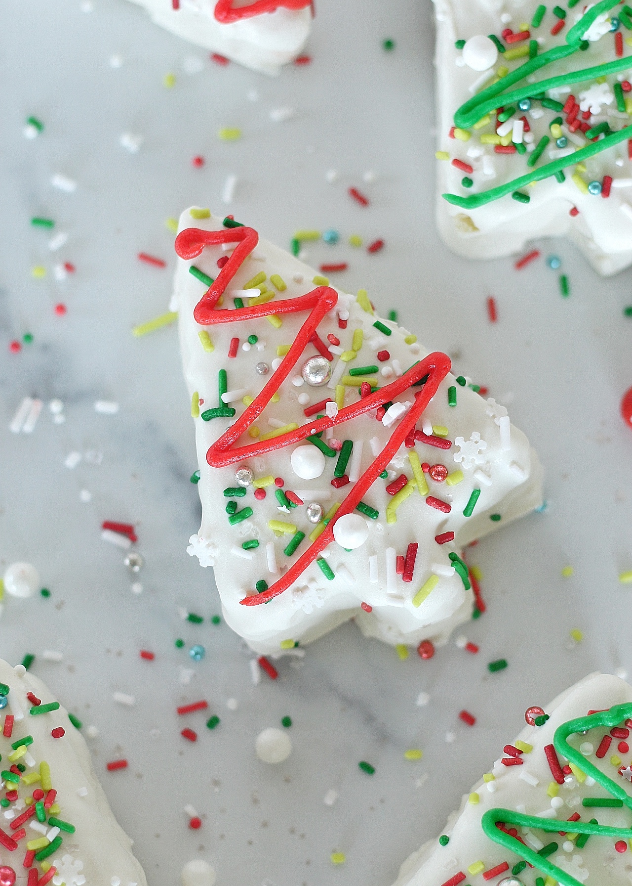 Christmas Tree Cakes with sprinkles on a plate.