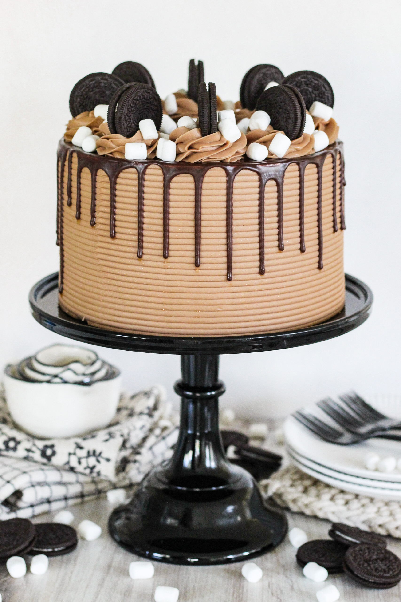 Chocolate cake with Oreos on top on a black cake stand.