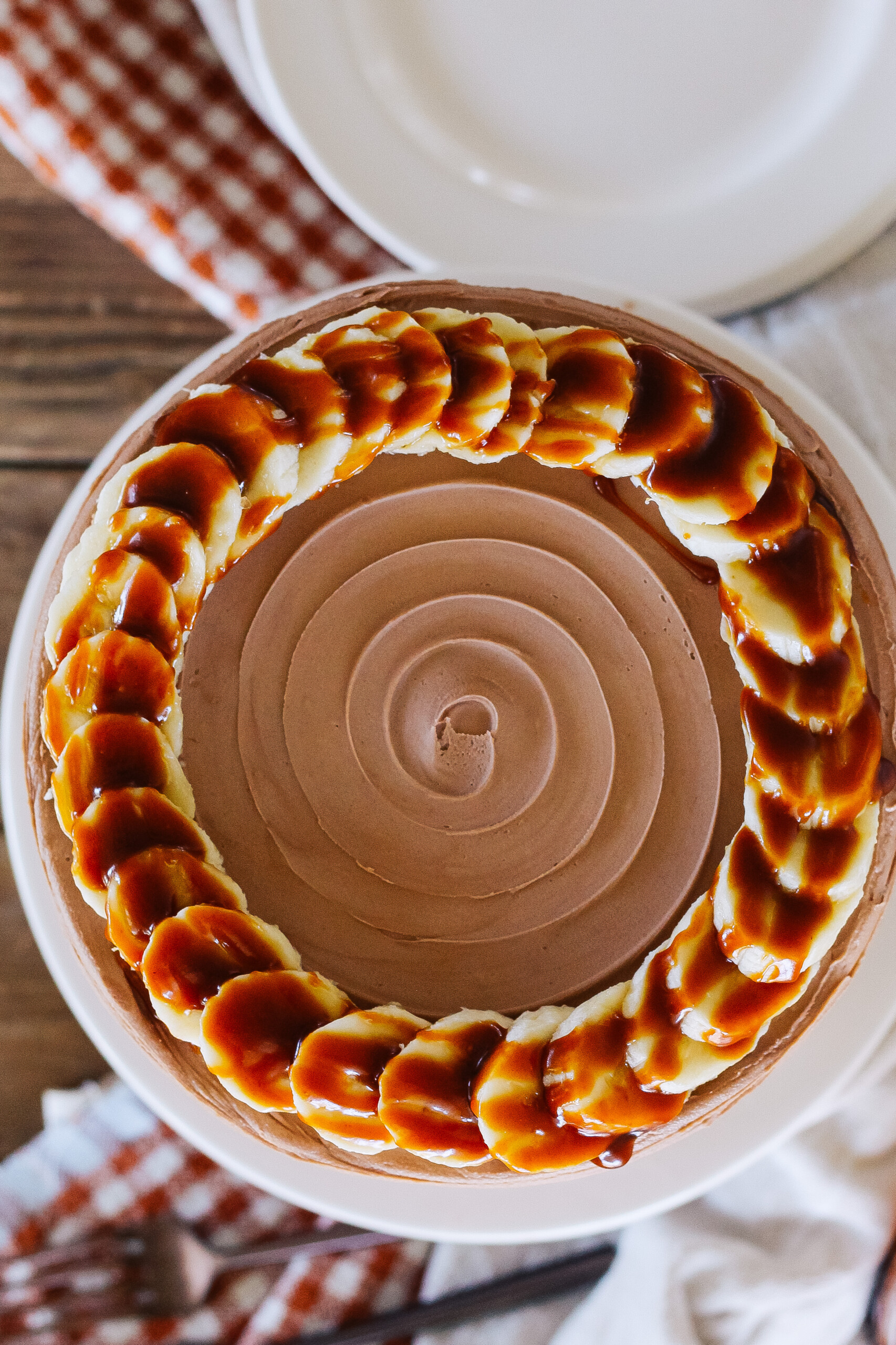 Top view of a cake with bananas and caramel on it.