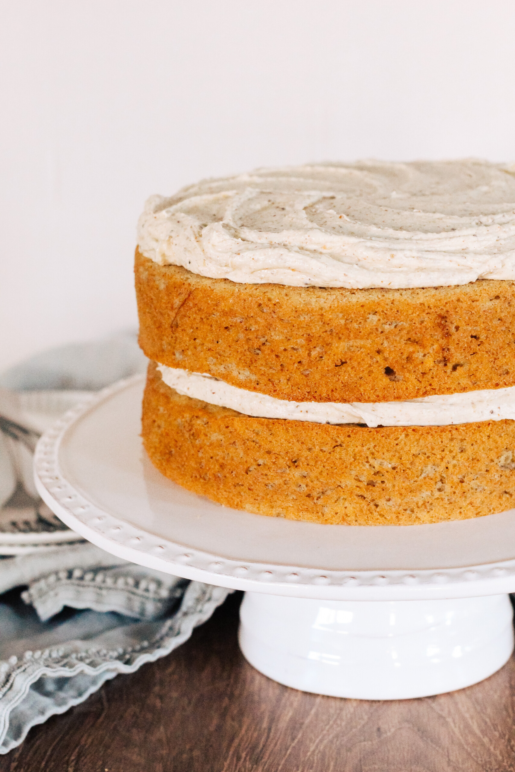 Two layer Banana Chai Cake on a cake stand.