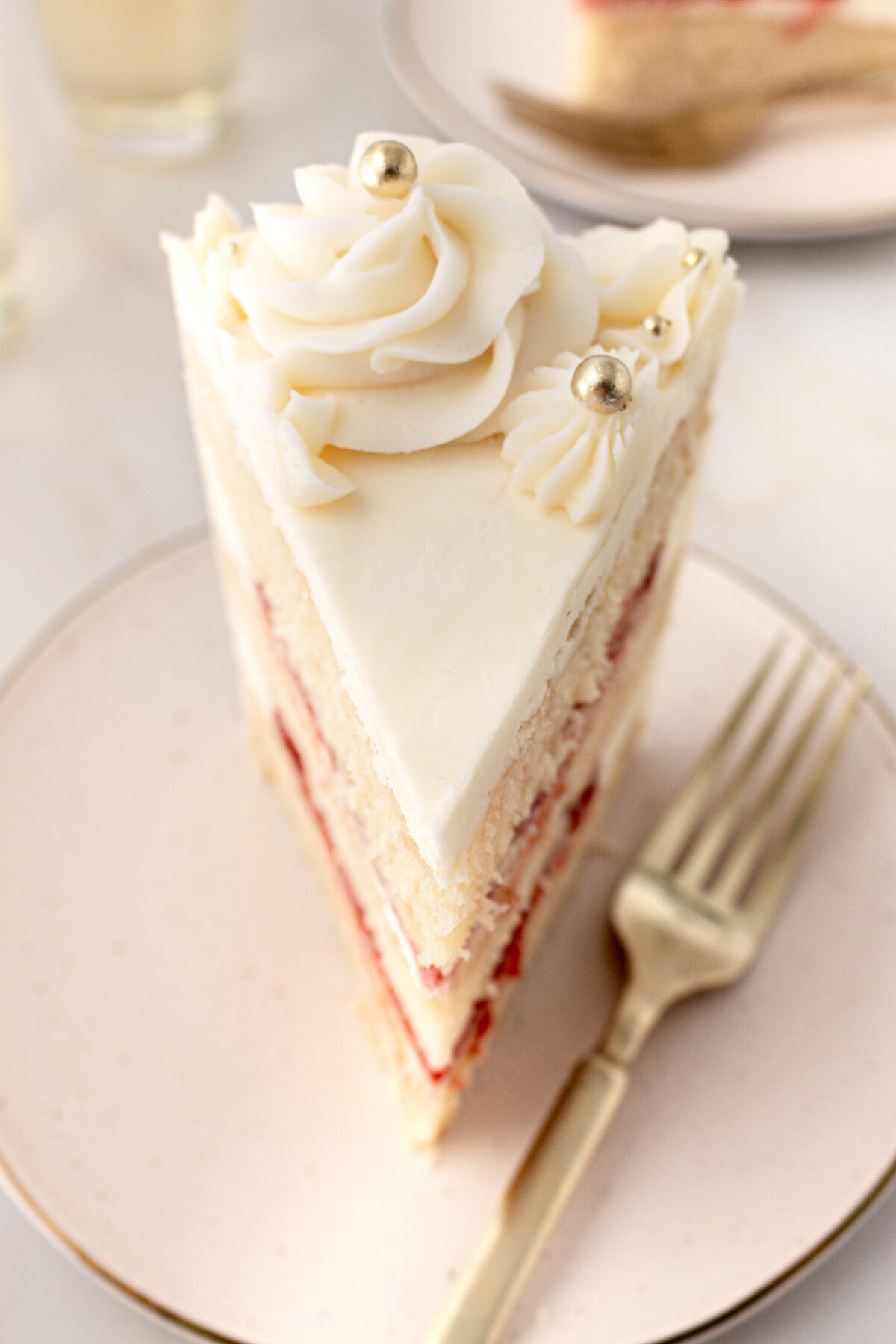 A slice of a cake on a pink plate.