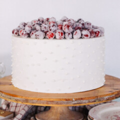 Cake on a cake stand with candied cranberries.