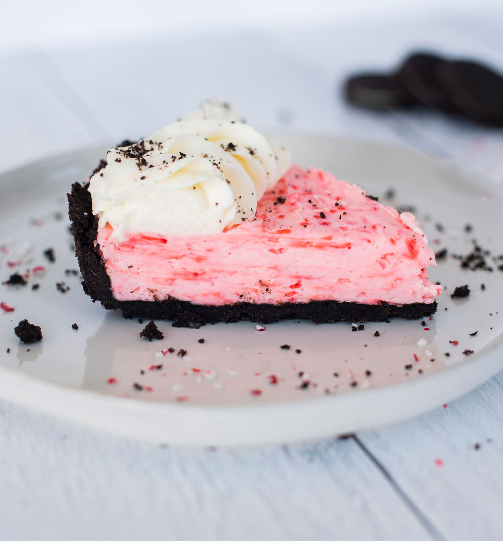 A slice of peppermint pie on a plate with Oreos.