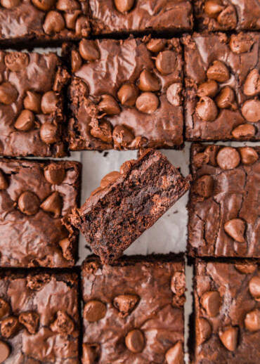 Brownies cut into squares on parchment paper.