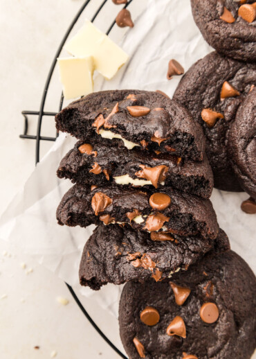 Chocolate cookies split in half on a cooling rack.