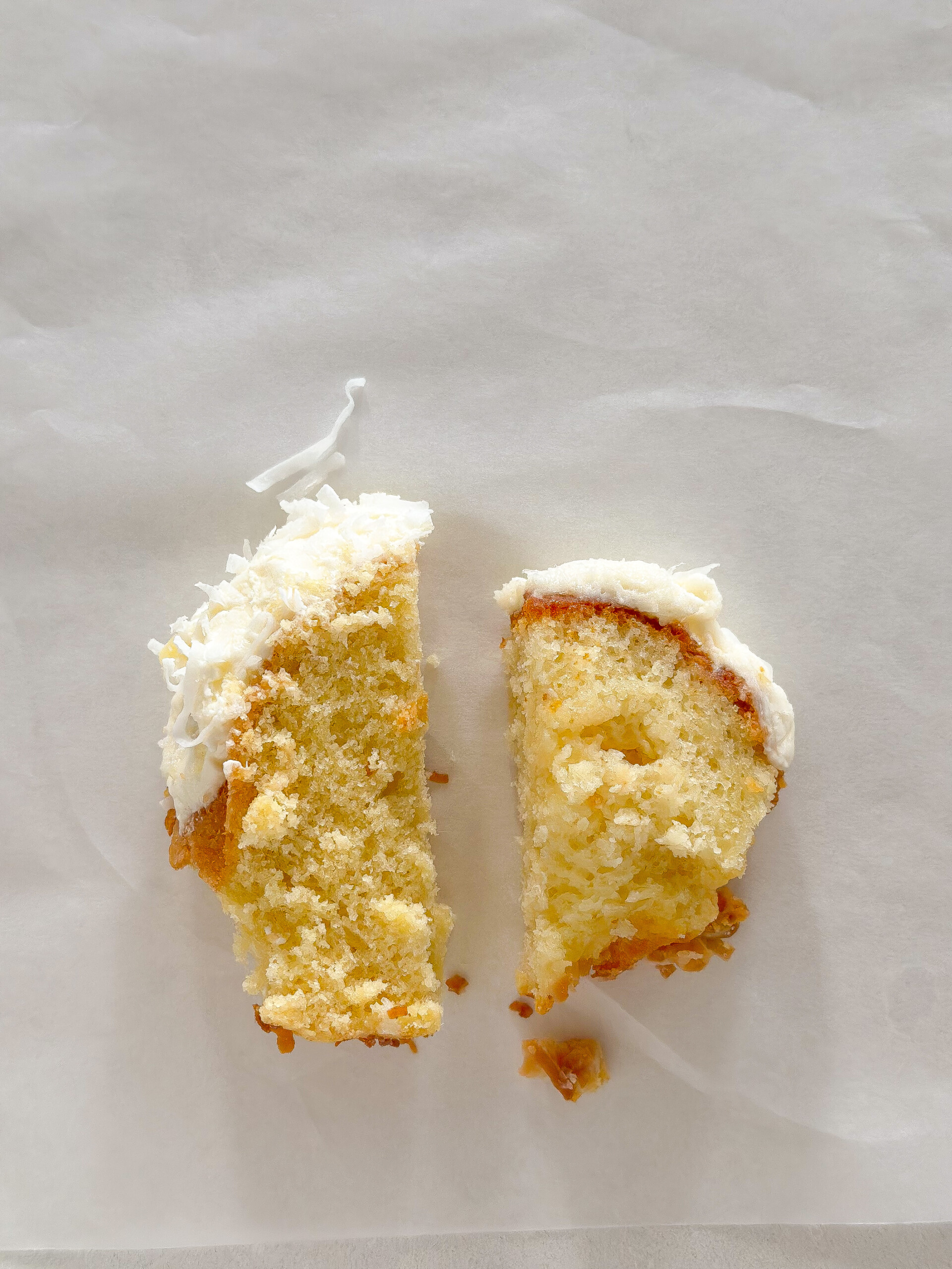 Two cake slices next to each other on parchment paper.