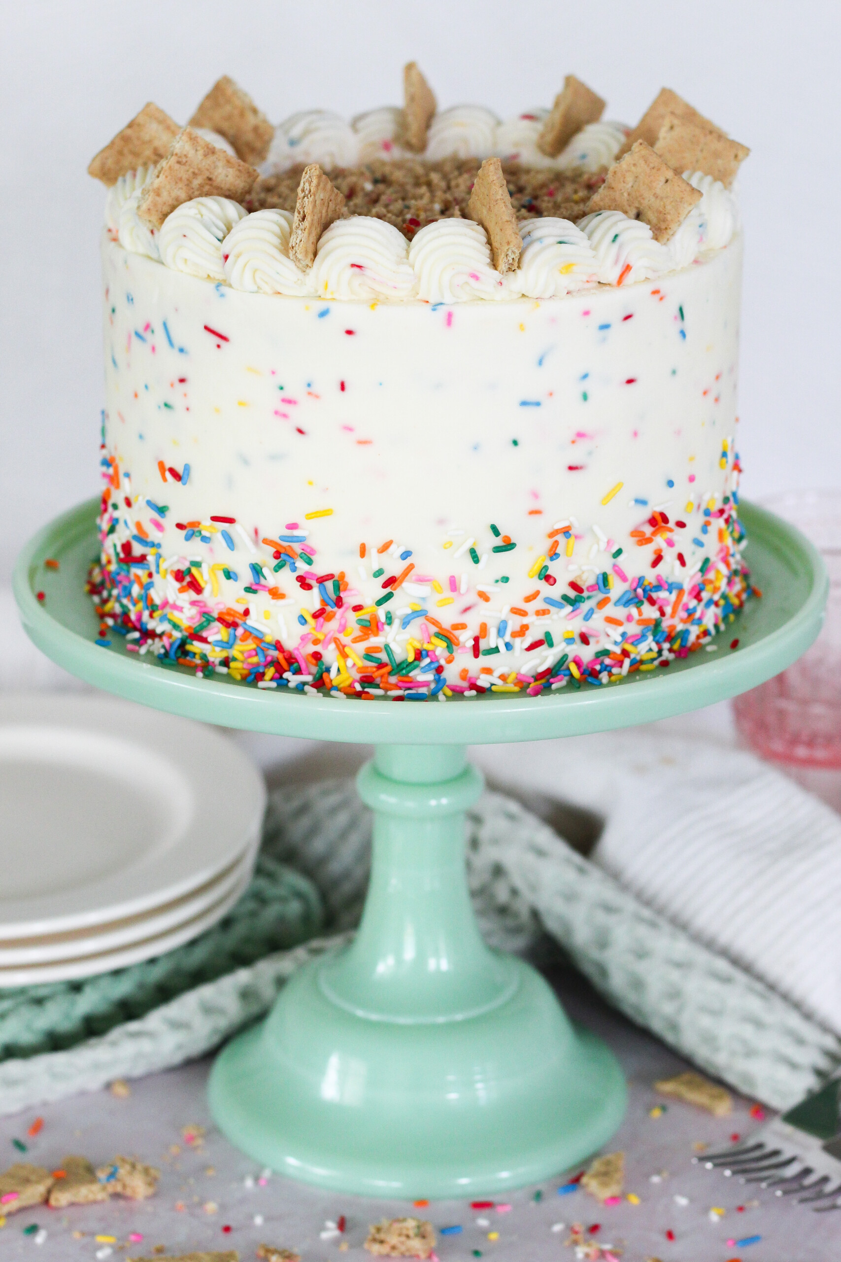 A confetti cake on a green cake stand.