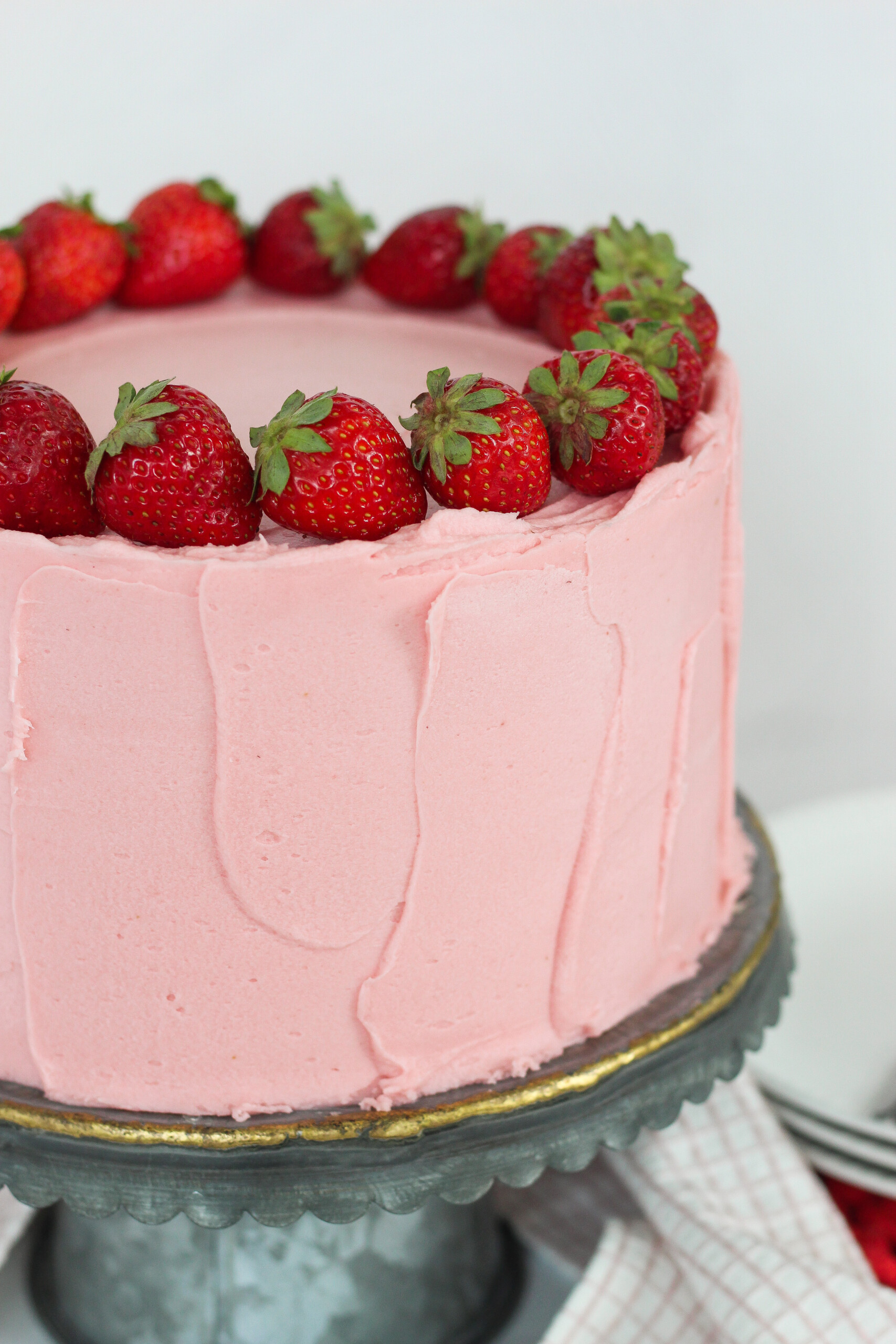 A strawberry cake with strawberry buttercream and fresh strawberries.