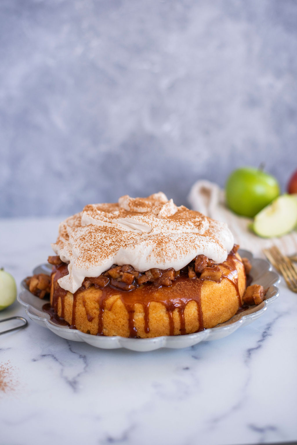 Cake on a serving dish with apples.
