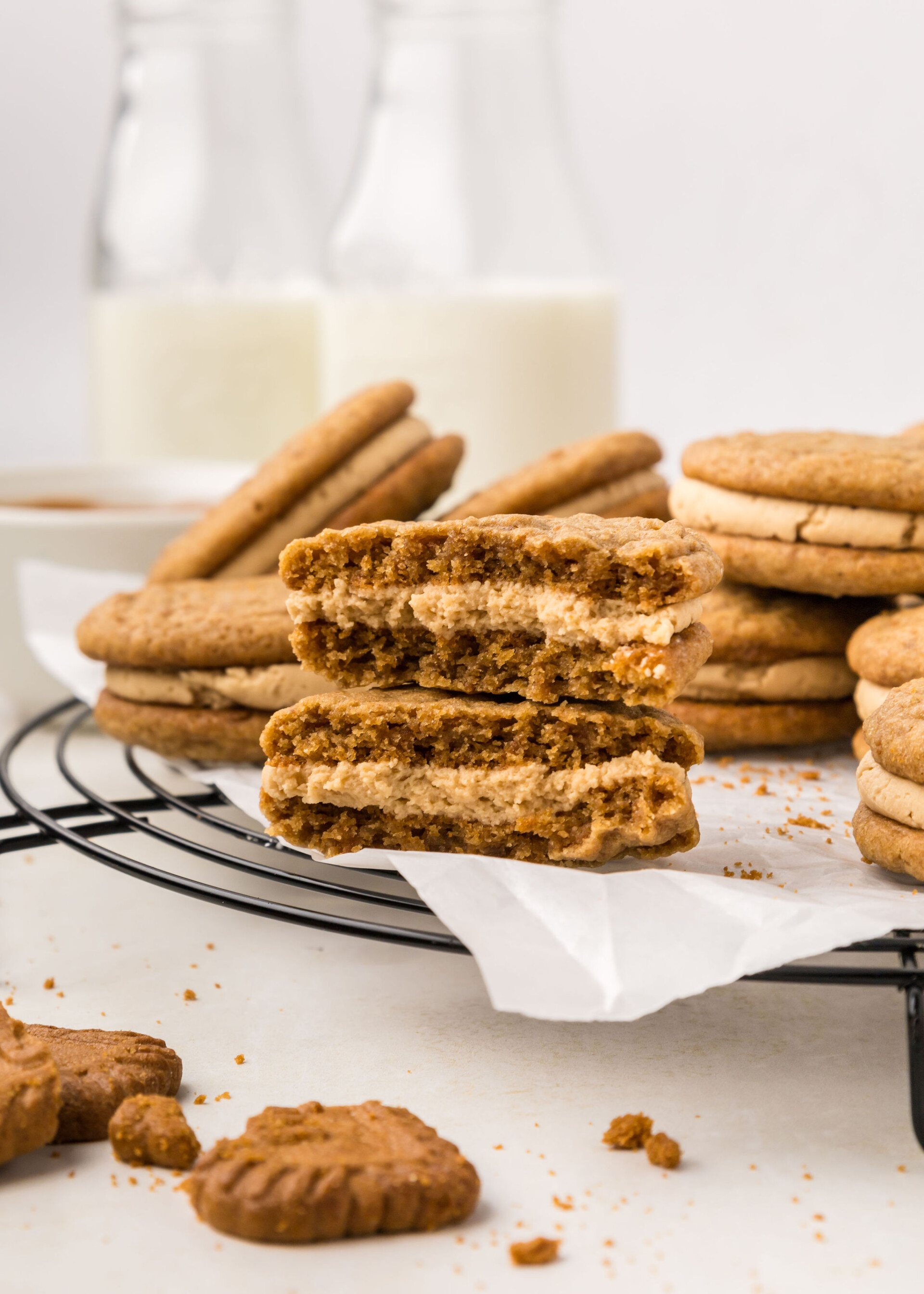 Biscoff sandwich cookies on a cooling rack with milk.