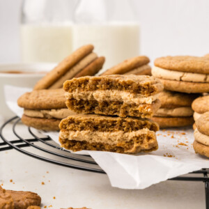 Biscoff sandwich cookies on a cooling rack with milk.