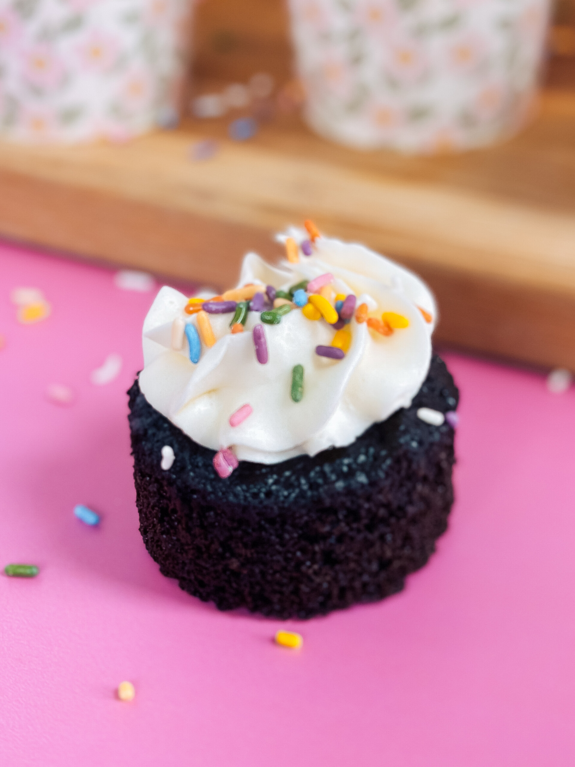 A chocolate cupcake on a pink background.