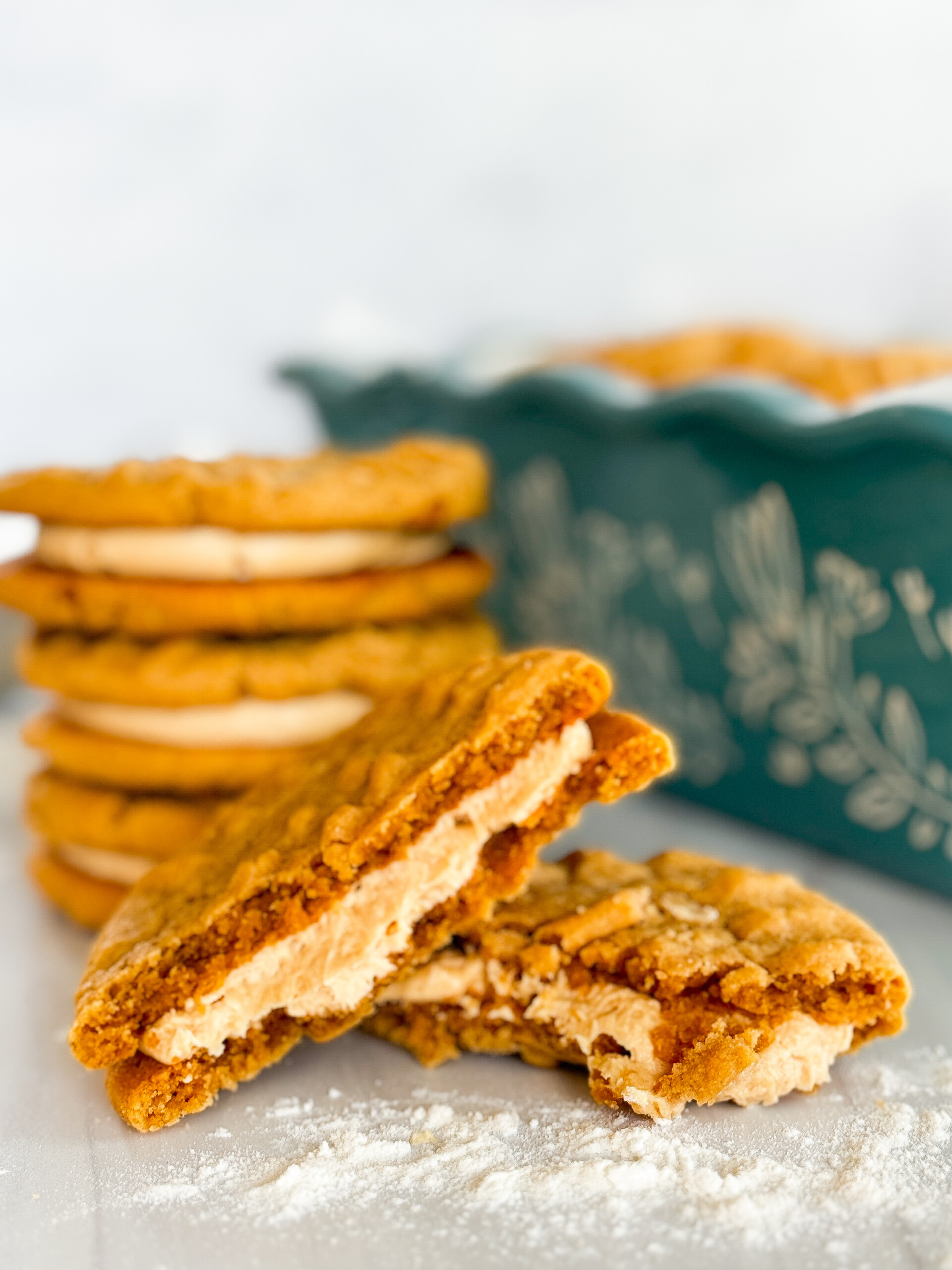 A peanut butter sandwich cookie split in half with the buttercream spilling out.