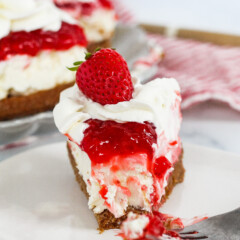 Slice of a no bake strawberry biscoff cheesecake on a plate.