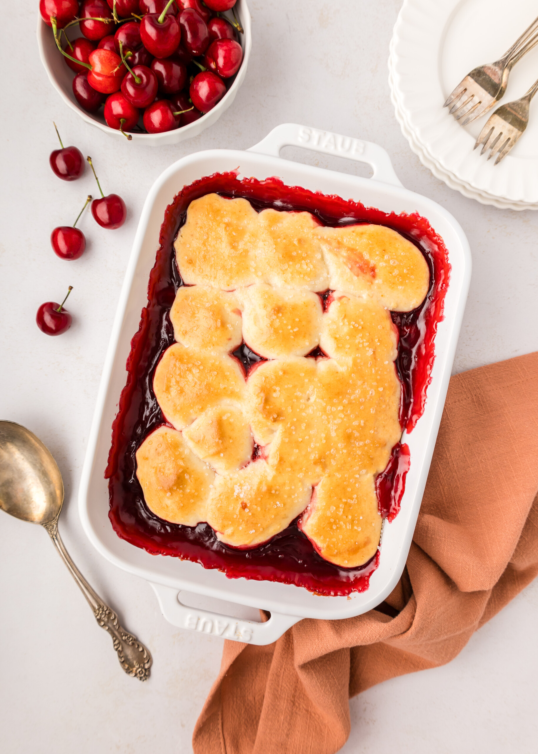 Cherry cobbler in a white baking dish.