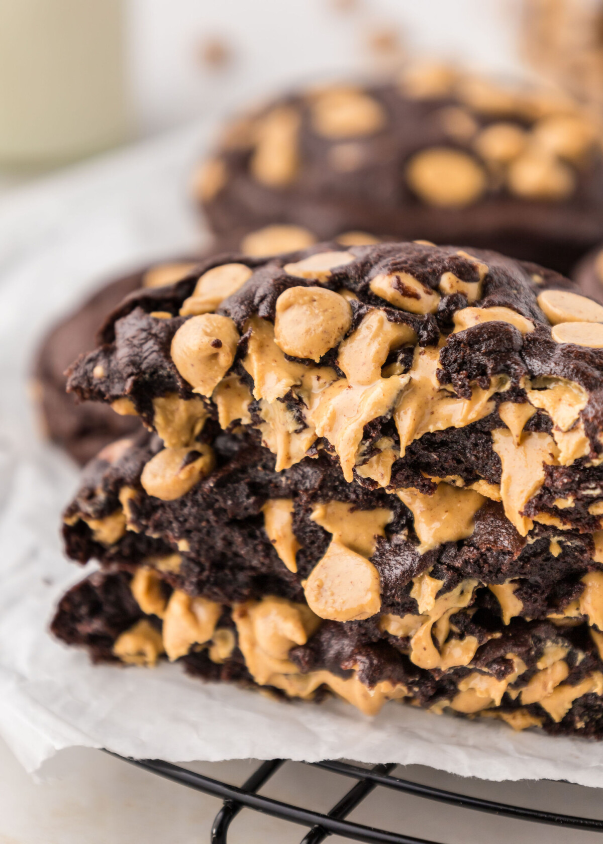 A stack of chocolate peanut butter chip cookies on a cooling rack.