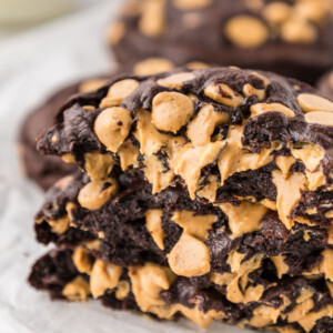 A stack of chocolate peanut butter chip cookies on a cooling rack.