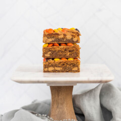 Stack of peanut butter blondie bars on a cake stand.