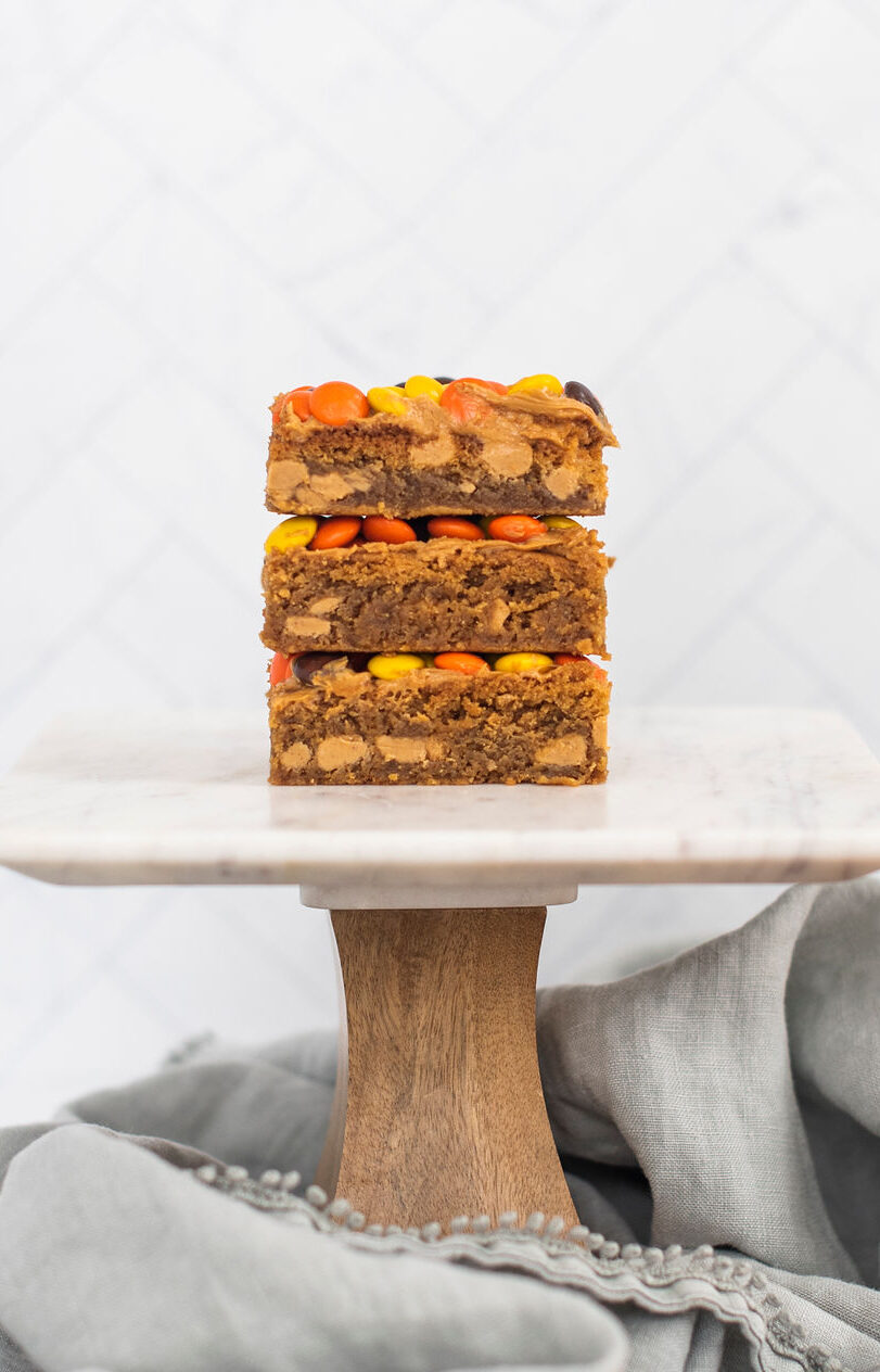 Stack of peanut butter blondie bars on a cake stand.