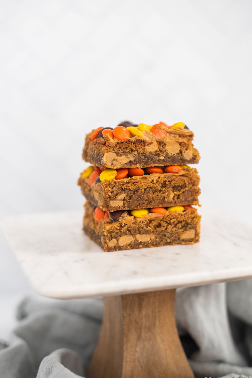 Stack of peanut butter blondies on a cake stand.