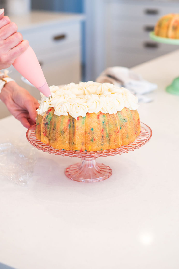 Piping buttercream on a bundt cake.