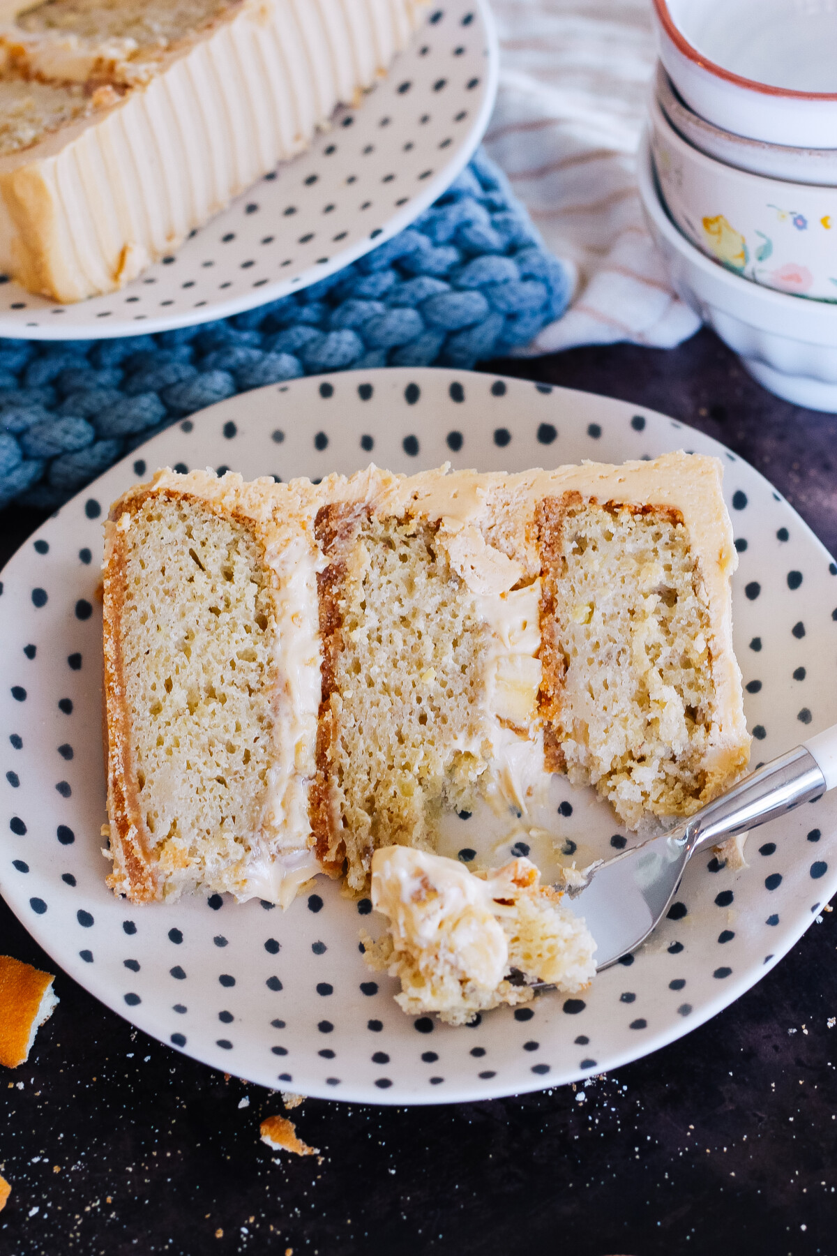 A slice of peanut butter banana cream cake with a bite taken out of it.