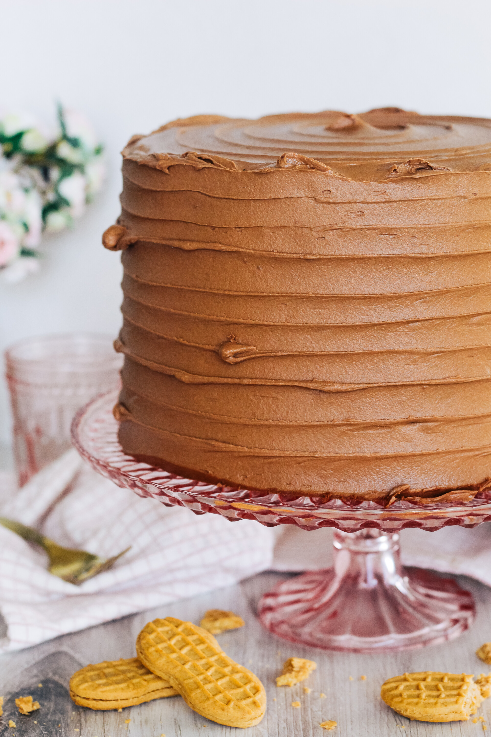 Peanut butter chocolate cookie layered cake on a pink cake stand.