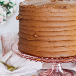 Peanut butter chocolate cookie layered cake on a pink cake stand.