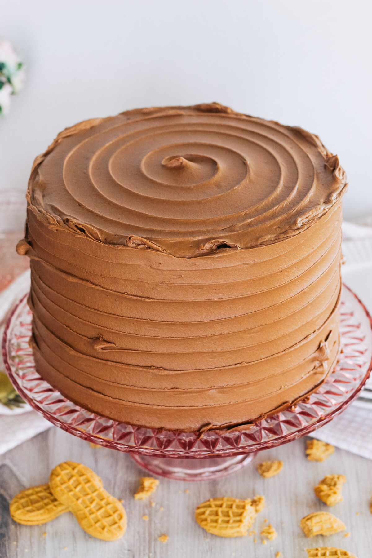 Chocolate cake on a pink cake stand.