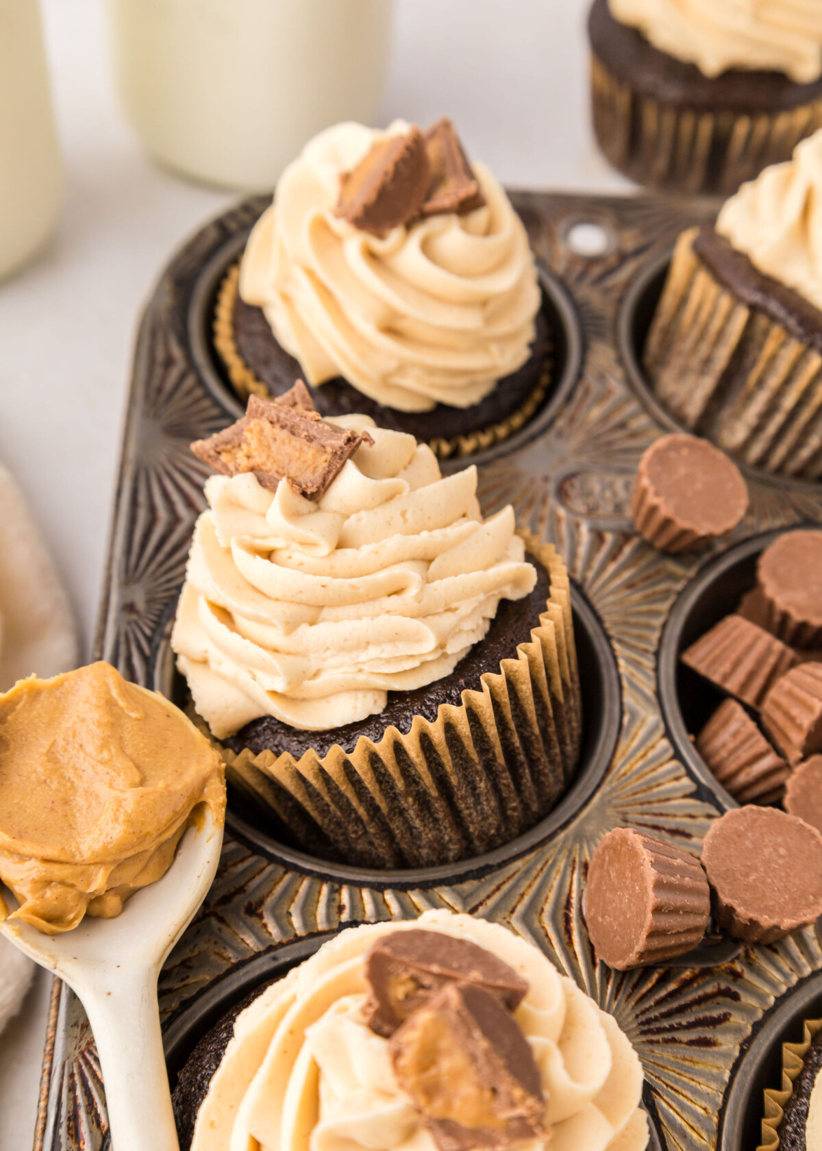 Chocolate cupcakes with peanut butter buttercream in a cupcake tin.