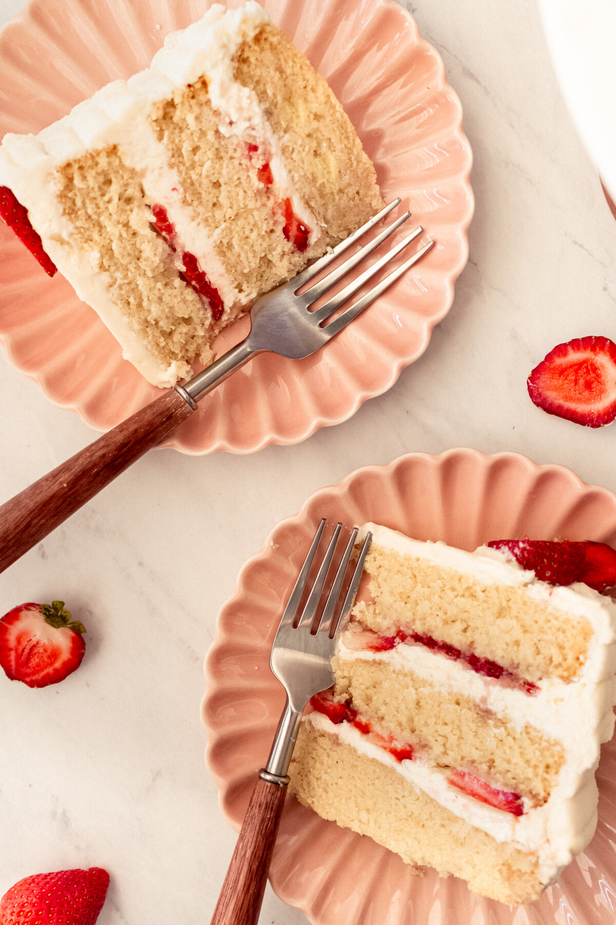 Two slices of cake on pink plates.