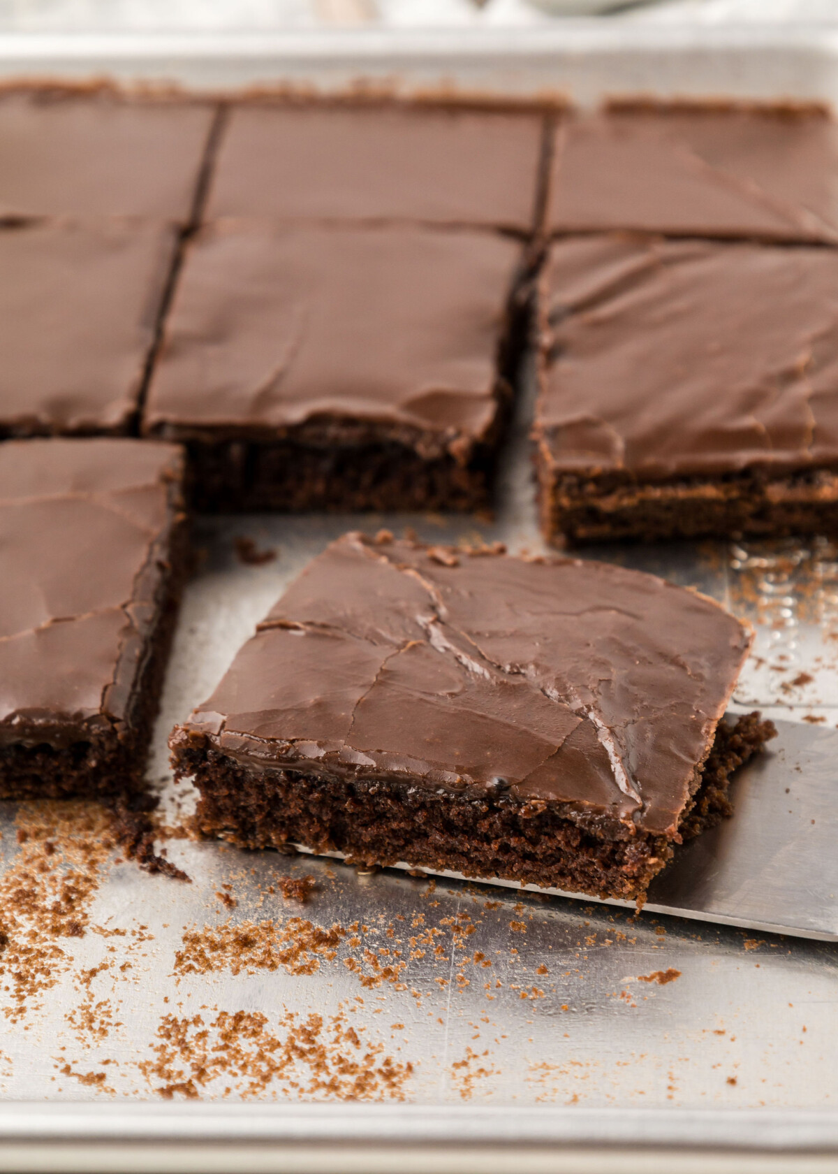 Texas Sheet Cake in a pan with a spatula removing one slice.